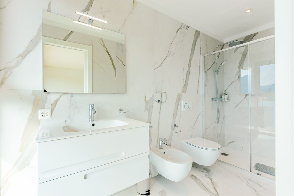 pexels photo 26747980 26747980 Elegant white bathroom featuring marble tiles and modern fixtures, perfect for a luxury home setting.