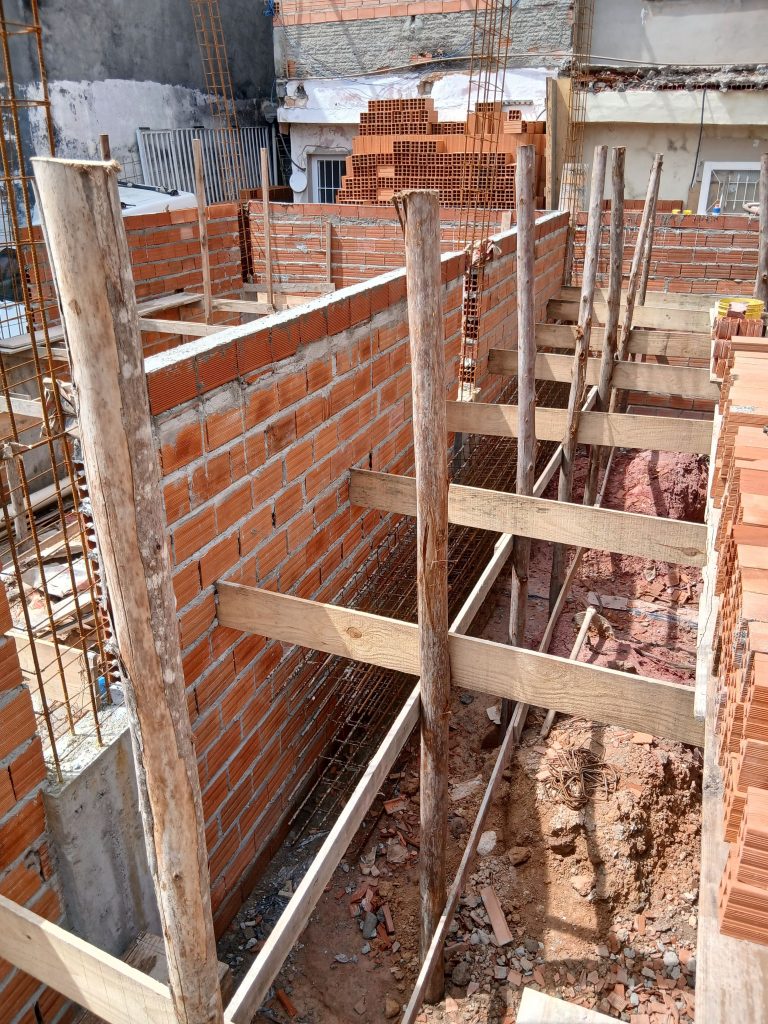 pexels photo 34640157 34640157 Construction site with brick walls and wooden supports under daylight.